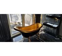 Bañera independiente de estilo retro, con estructura de composite y detalles dorados, sobre patas de león doradas. Bañera Ludwik negra con interior dorado